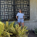A person wearing vintage blue happily berserk shorts with an elastic waistband and side pockets and raw edge cropped vintage blue t shirt 