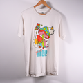 A vintage white short-sleeve t-shirt hanging on a wooden hanger against a light wall. The shirt features a colorful graphic print of a mushroom, flower, and butterfly with the text 'you are MAGIC' printed below.